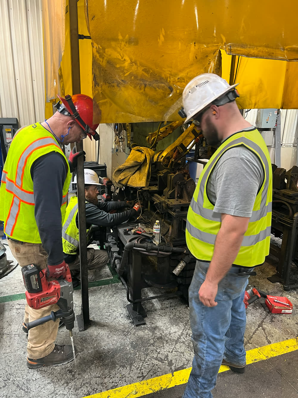 Unified Automation technicians servicing a robotic press cell on a customer's plant floor